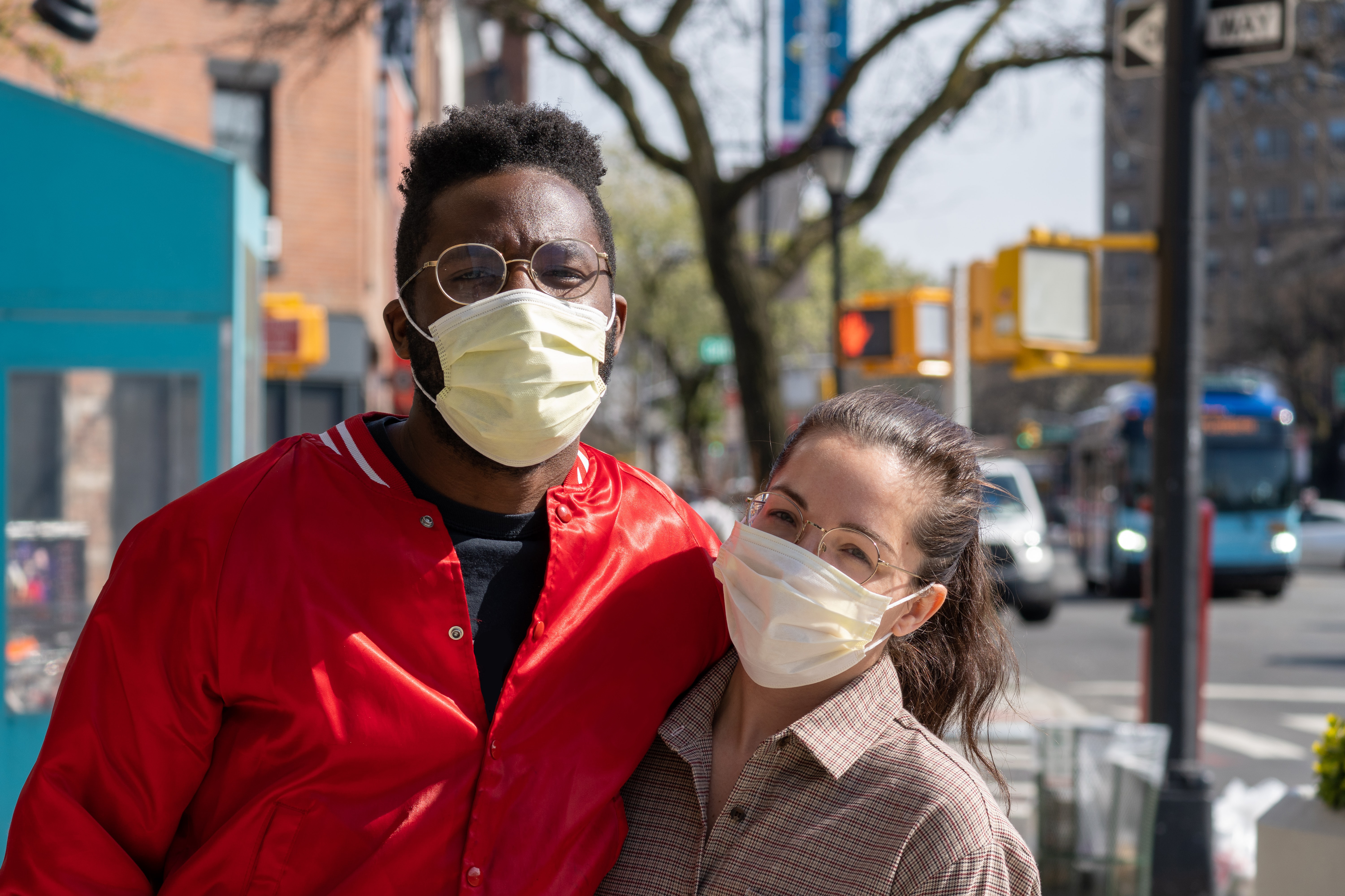Two people wearing masks on a city street