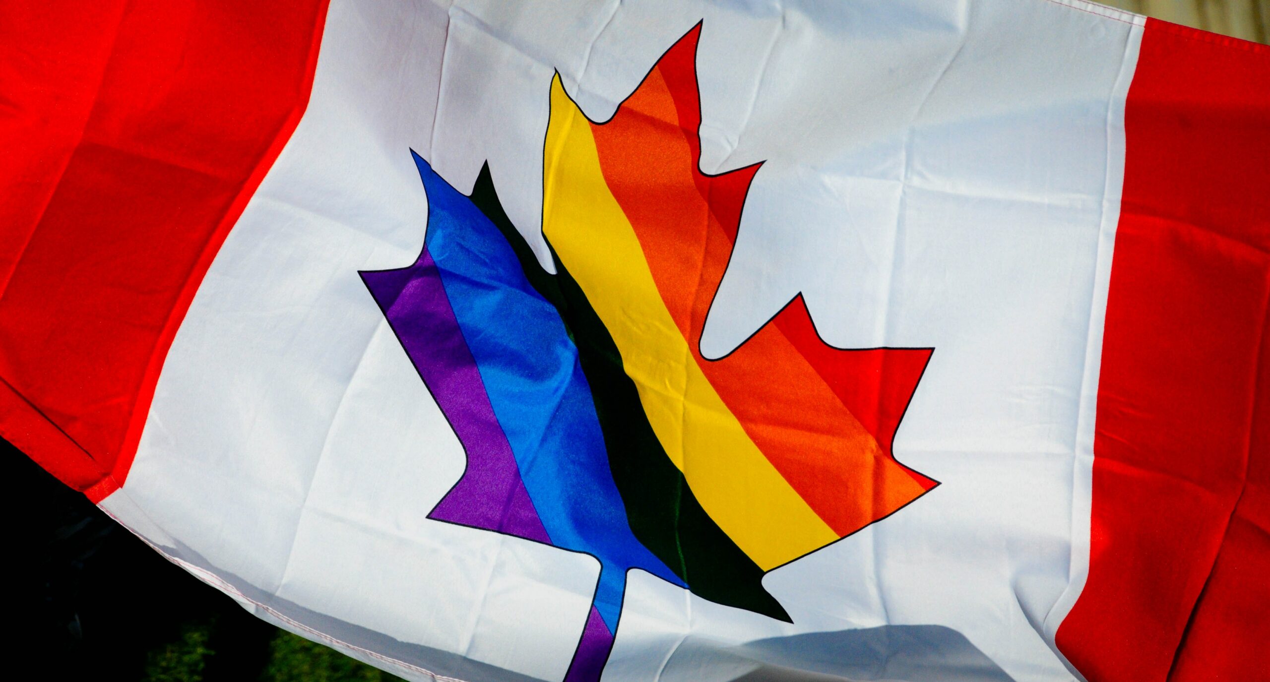 canadian flag with rainbow maple leaf