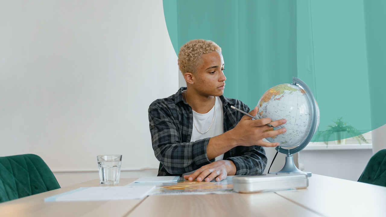 Man using and looking at a globe to see which country to export to for Startup Global 2022