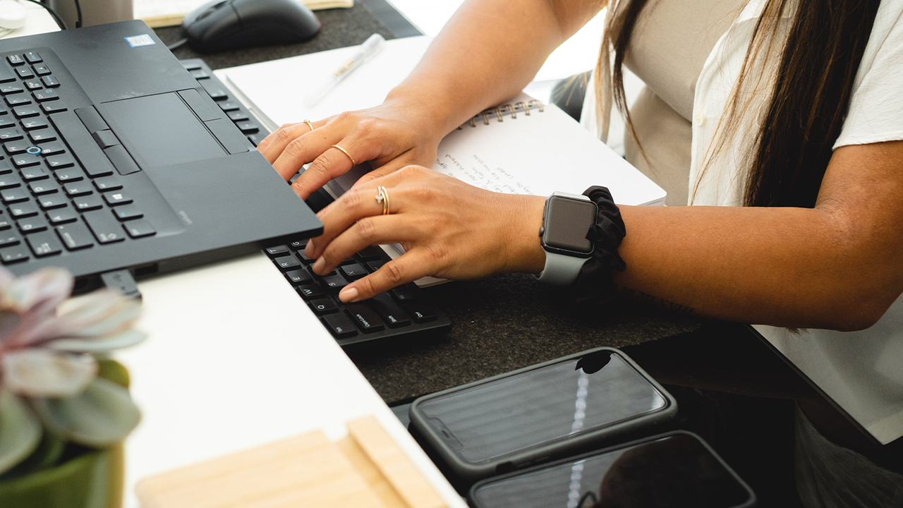 Someone typing business contracts on their laptop