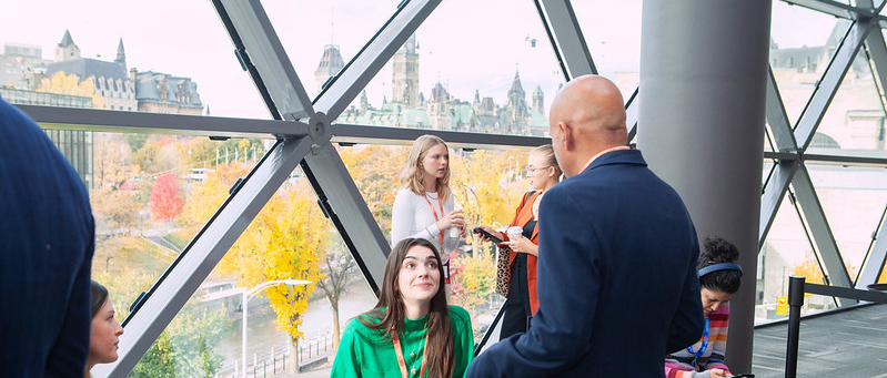 Man and woman interacting with the Ottawa Parliament in the background